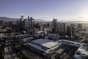 Downtown Los Angeles skyline glowing at sunrise above the freeway