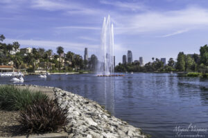 Echo Park Lake fountain surrounded by palm trees with the Downtown Los Angeles skyline in the background