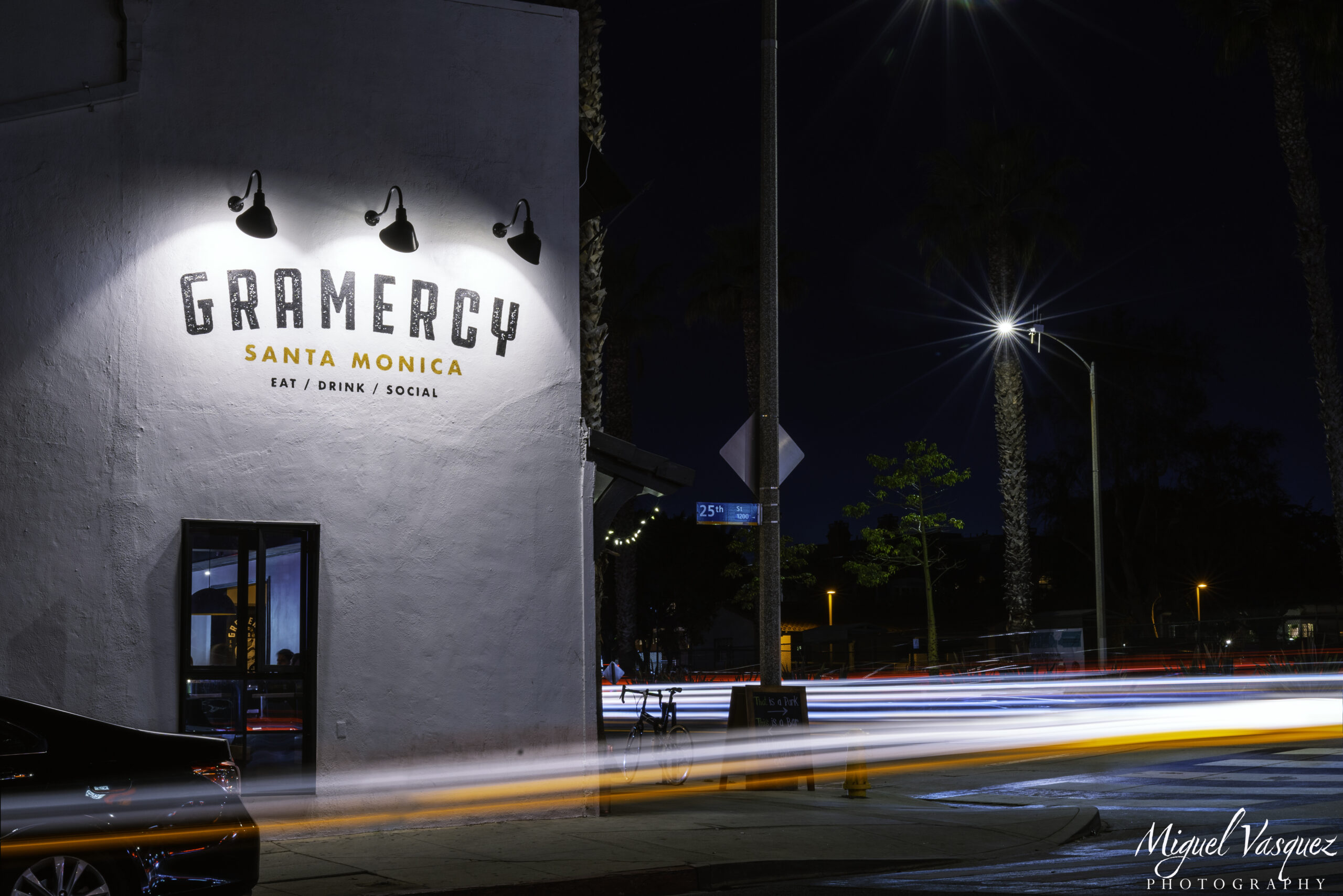 Gramercy restaurant sign lit up at night in Santa Monica with car light trails