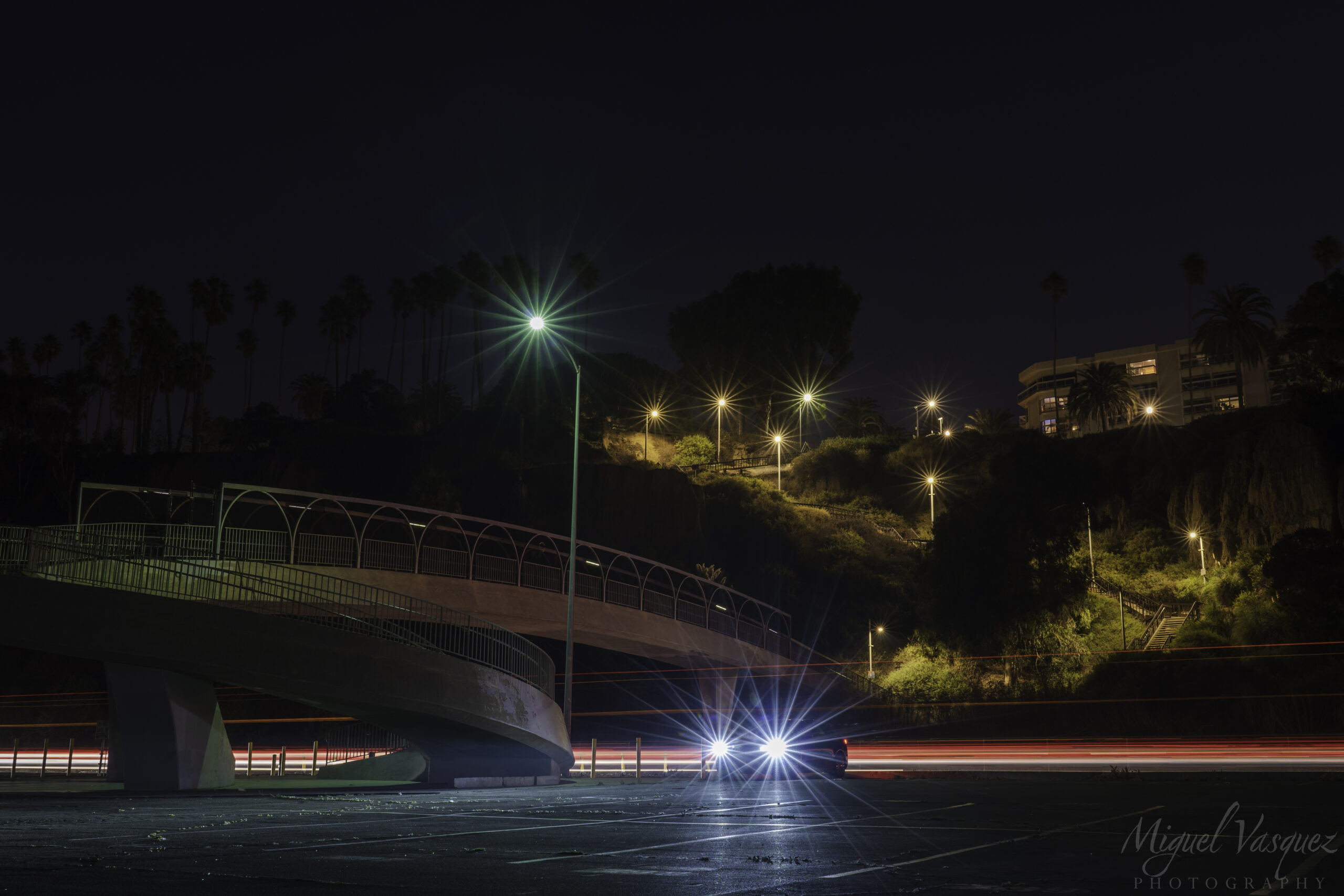 Night photo of the Santa Monica bluffs pedestrian bridge over PCH with car light trails
