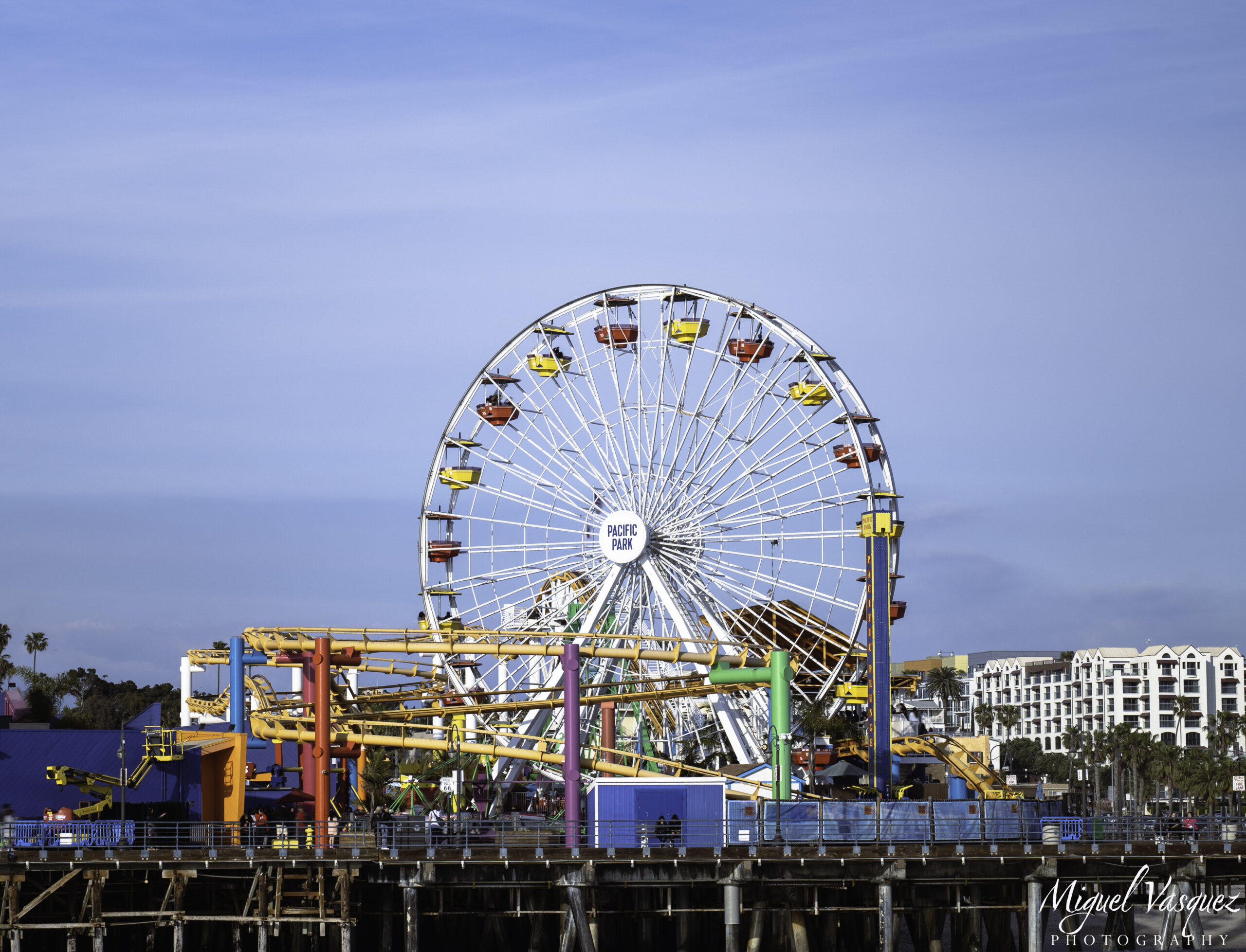 Santa Monica Pier's Pacific Park Ferris wheel lit up during blue hour